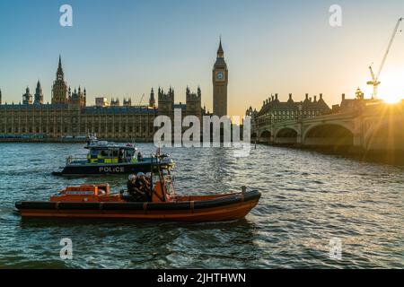 THE HOUSES OF PARLIAMENT, LONDON, ENGLAND, JUNE 22, 2022. Police and RNLI Rescue boats on The River Thames by Big Ben, The Houses of Parliament and We Stock Photo