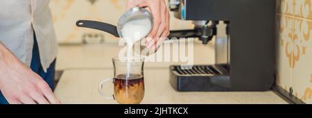 Handsome man using coffee machine in kitchen BANNER, LONG FORMAT Stock Photo