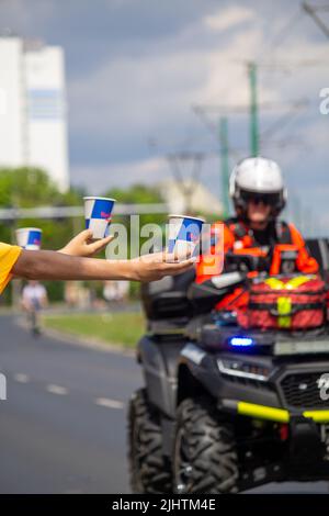 The volunteers offering water to the runners at Wings for Life World Run Stock Photo