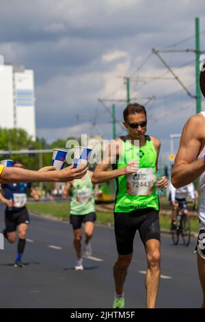 The volunteers offering water to the runners at Wings for Life World Run Stock Photo