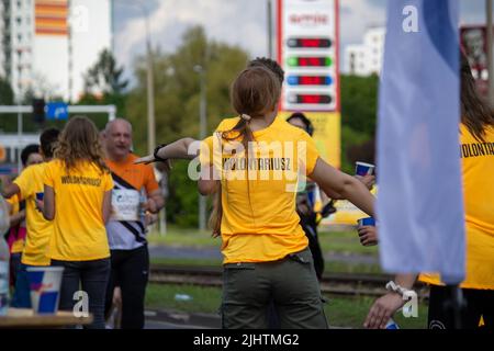 The volunteers offering water to the runners at Wings for Life World Run Stock Photo