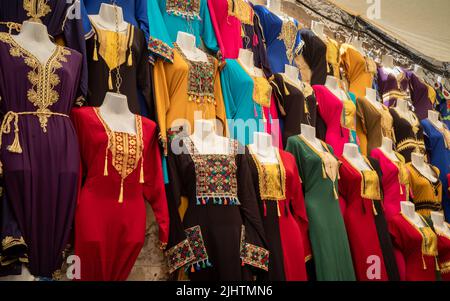 Colourful traditional women's dresses and robes for sale in the Medina of Sousse in Tunisia. Stock Photo