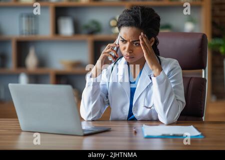 Black woman doctor having conversation with upset sick man patient ...