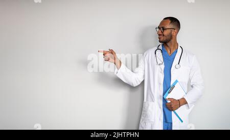 Handsome middle eastern doctor pointing at copy space Stock Photo