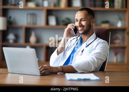 Smiling middle eastern therapist having phone call with patient Stock Photo