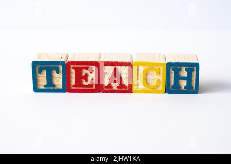 The word Teach spelled with colorful toy blocks on a white background Stock Photo