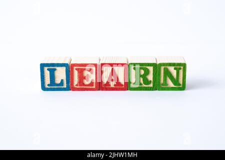 The word Learn spelled with colorful toy blocks on a white background Stock Photo