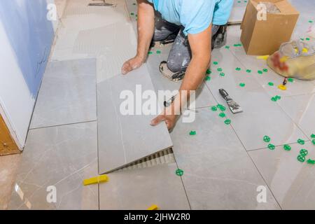 Laying ceramic tiles on glue in floors with tile adhesive Stock Photo