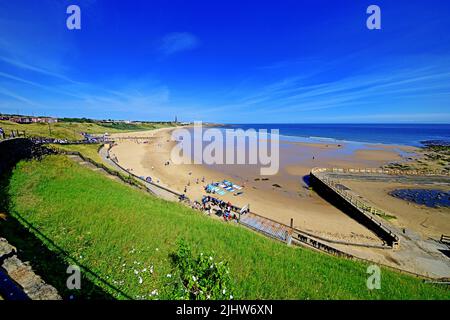 Tynemouth Long sands beach wideangle vista with canoeists surfers deep blue sky with light cirrus Stock Photo