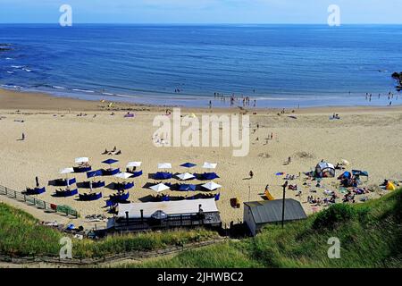 King Edwards Bay beach Tynemouth and Rileys Fish Bar restaurant people bathing swimming having picnics tide out and blue sky Stock Photo