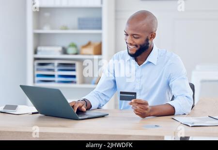 This will only take a second. a young businessman using a credit card and laptop at work. Stock Photo