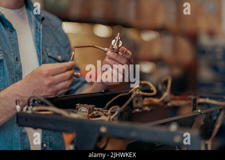Close up of man hands repairing coffee machine in a workshop Stock Photo