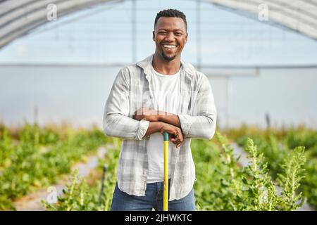 Theres something about doing the work yourself.... a handsome young man working on his farm. Stock Photo