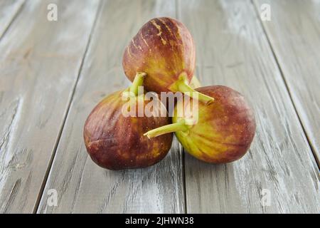 Fresh figs stacked in bunch on wooden background. Stock Photo