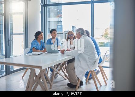 Its easier to diagnose when we work together. Full length shot of a group a medical professionals sitting in the hospital boardroom during a meeting. Stock Photo