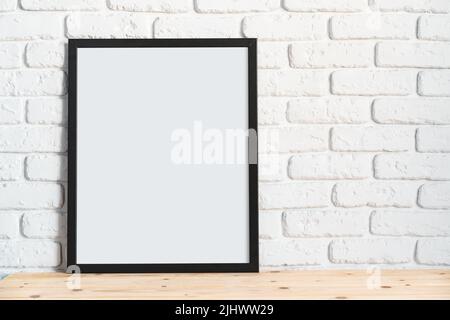 Photo frames on floor over white brick wall Stock Photo