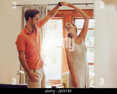 Lets dance until our feet hurt. a young couple dancing together at home. Stock Photo