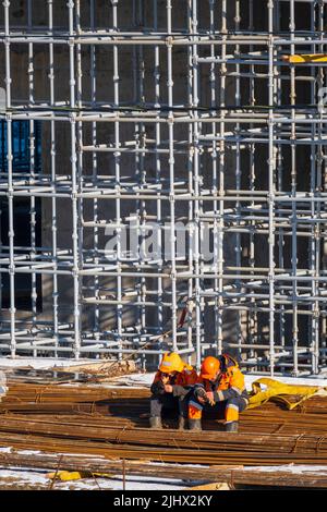 Unrecognizable builders using smartphones during break Stock Photo