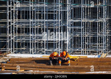 Unrecognizable builders using smartphones during break Stock Photo