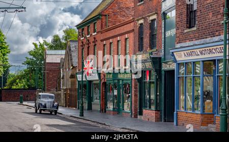 A Vintage Morris Eight car parked along a Victorian village street at the Black Country Living Museum, Dudley. Stock Photo