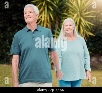 Hand in hand through all of lifes ups and downs. an affectionate senior couple outside in their garden at home. Stock Photo