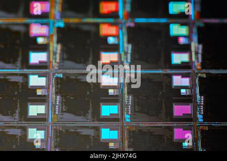 Silicon wafer with microchips used in electronics for the fabrication of integrated circuits. Full-frame high-tech macro background. Stock Photo