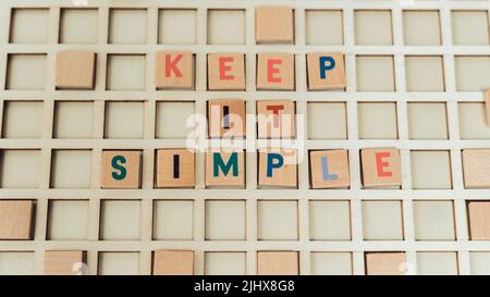 Wooden blocks in a grid word game colorful letters. Keep it simple. Advice. Advertisment concept. High quality photo Stock Photo