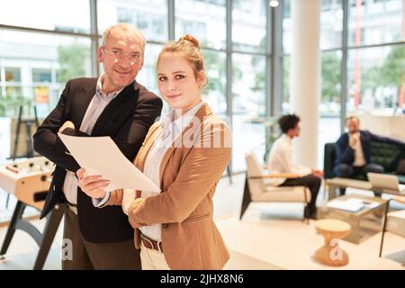 Older business man as a successful consultant and young colleague as a trainee in the office Stock Photo