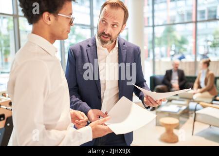 Business consultant and young startup founder discuss a risky business plan Stock Photo
