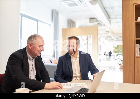 Two business people as managers having a casual conversation during a break in the office Stock Photo