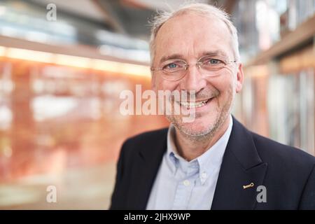 Senior businessman as a successful entrepreneur smiles with satisfaction Stock Photo