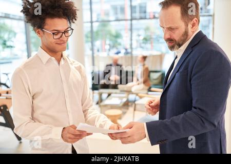 Startup founders and business partners look at the business plan or annual report Stock Photo