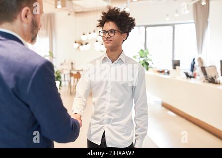 Young business man and manager shaking hands for greeting and partnership Stock Photo