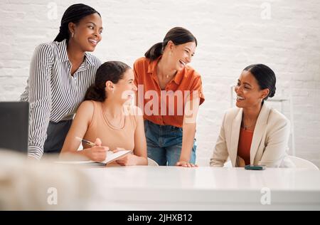 Group of happy diverse businesswomen having a meeting together in a boardroom at work. Cheerful businesspeople talking and planning in a workshop in Stock Photo