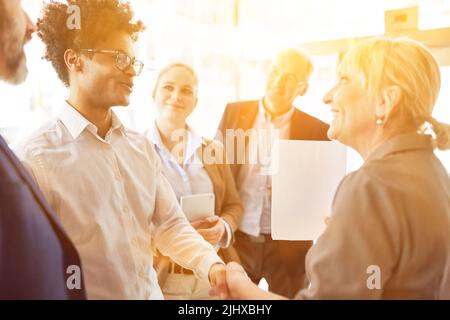 Successful business people shake hands while working together in office Stock Photo