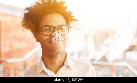 African businessman with glasses and afro hairstyle smiling in the office Stock Photo