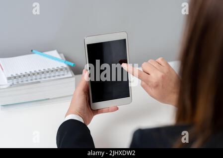 Businesswoman Holding Tablet And Pointing With One Finger On Important Message. Executive In Suit Presenting Crutial Information. Woman Showing Stock Photo