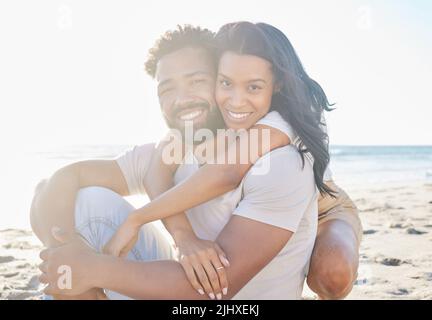 A little thing called love. Cropped portrait of an affectionate young couple sitting on the beach. Stock Photo