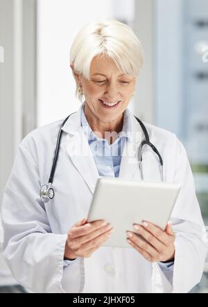making the most of the technological world. a confident mature doctor using a digital tablet. Stock Photo