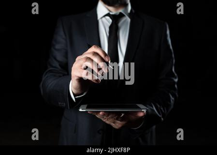 Businessman Holding Tablet In One Hand With Other Pointing Important Message With Pen. Executive In Suit Having Cellphone In One Palm And Crutial Stock Photo