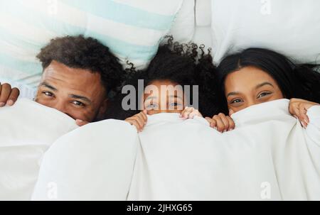 Peekaboo, where are you. a young family relaxing at home. Stock Photo
