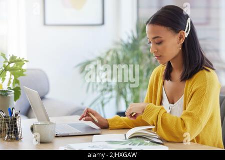 Being a business owner takes sacrifice. a young businesswoman working in a modern office at work. Stock Photo