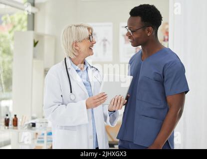 We need to come up with a treatment plan. two medical doctors having a discussion while using a digital tablet. Stock Photo