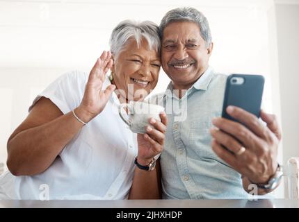 Wave and say hi. a senior couple on a call together at home. Stock Photo