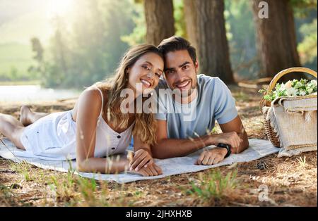 Enjoying picnic time. a young couple having a picnic in the forest. Stock Photo