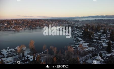 An aerial drone view of Lake Stevens surrounded by trees and houses in winter Stock Photo