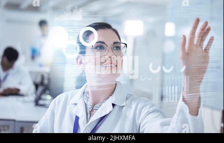 Checked into the future. a young female lab technician using an interactive board. Stock Photo