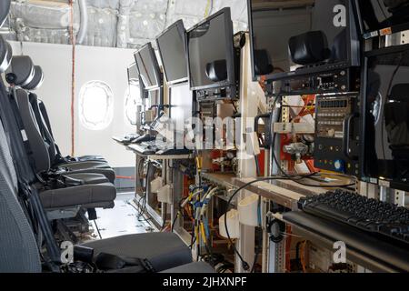 Flight testing equipment in the cabin of a Boeing 777X jet airliner, at the Farnborough Airshow, on 20th July 2022, at Farnborough, England. As a result of the fatal accidents of the 737 Max, the 737 fleet was grounded around the world and Boeing is now recovering from a resulting financial downturn. The flight test cabin is configured for computer work stations and cabling which relay data while water ballast transfers weight and centre-of-gravity information to sensors during flight, gathering callibrated performance information before official the aircraft's eventual certification. Stock Photo