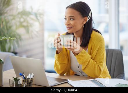 Coffee gives me motivation. a young businesswoman drinking coffee in a modern office at work. Stock Photo
