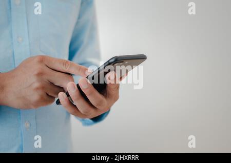close up man hand holding mobile smartphone copy space.person texting text message internet technology concept. Stock Photo